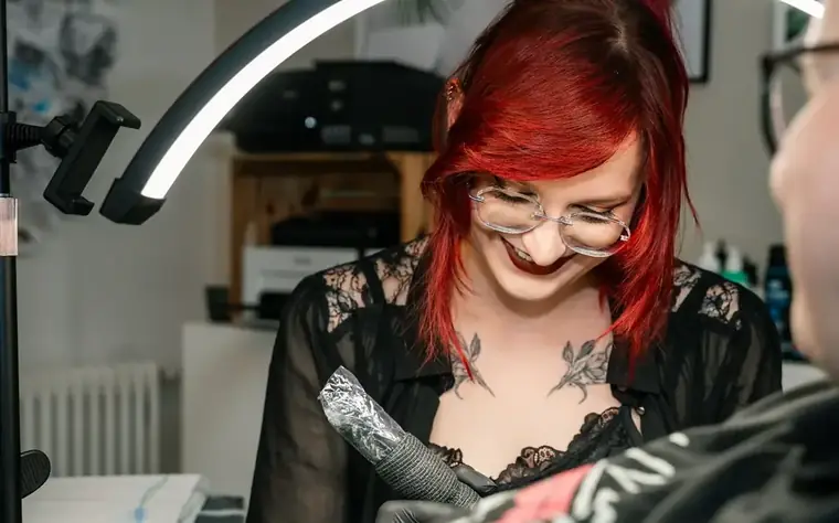 Ely Elumy bei der Arbeit an einem Tattoo