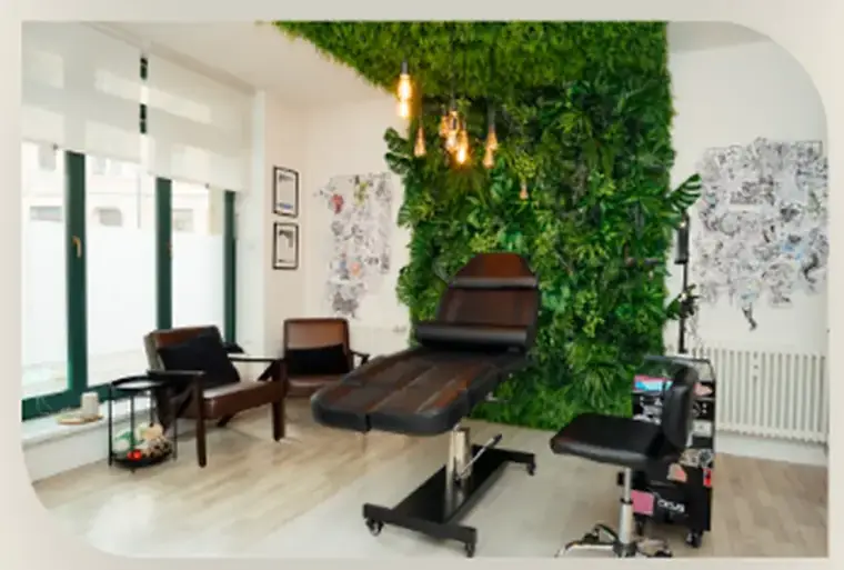 Heller Blick ins Evergreen Ink Studio mit Pflanzenwand und Sitzbereich